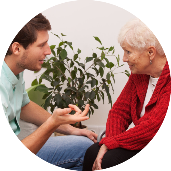 male caregiver and elderly woman talking